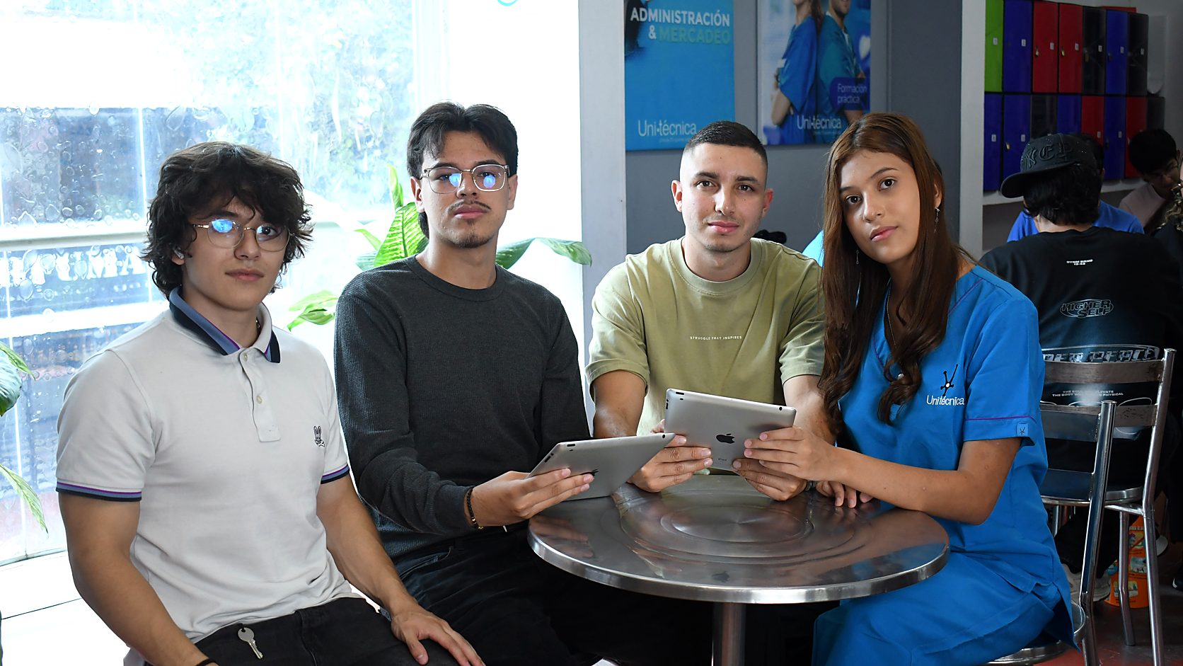 Estudiantes de Unitécnica comparando opciones de carrera técnica con tablets